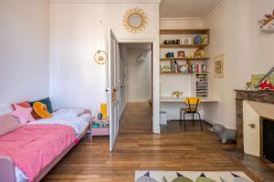 a bedroom with a pink bed and a fireplace at Grande maison kids friendly avec jardin in Angers