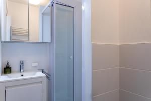 La salle de bains est pourvue d'une douche, d'un lavabo et d'un miroir. dans l'établissement Grande maison kids friendly avec jardin, à Angers