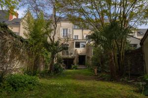 une maison au milieu d'une cour arborée dans l'établissement Grande maison kids friendly avec jardin, à Angers