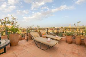 a balcony with two chairs and a table on a balcony at Riad Les Trois Palmiers El Bacha in Marrakech