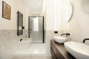 a white bathroom with two sinks and a toilet at Art Lover Apartment in Milan +19 photos