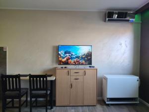 a room with two chairs and a tv on the wall at Left Coast studio apartment in Belgrade