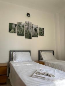 two beds in a room with pictures on the wall at Olive Villas in Nea Skioni