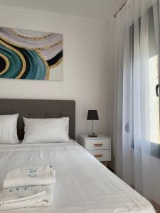 a bedroom with a bed and a painting on the wall at Olive Villas in Nea Skioni