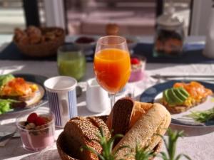 Private Exclusive Catamaran 'Hang Loose' في برشلونة: طاولة مع أطباق من الطعام وكأس من عصير البرتقال