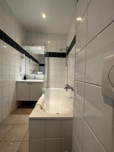 a white bathroom with a tub and a sink at Arriate Hotel in Lochristi