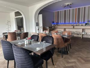 een restaurant met tafels en stoelen in een kamer bij Arriate Hotel in Lochristi