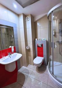 a bathroom with a toilet and a sink and a shower at GLORIETTA Apartments & SPA in Iwonicz-Zdrój +17 photos