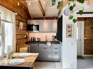 a kitchen with a table and a wooden wall at Romantic cottage with sauna in Porvoo