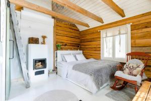 a bedroom with a bed and a fireplace at Romantic cottage with sauna in Porvoo