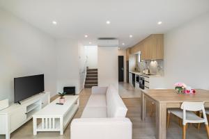 a living room with a couch and a table at Te Atatu Cozy Brand New House 4 in Auckland