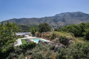 a house with a swimming pool and mountains in the background at Kournas Nature's Nest in Kournás