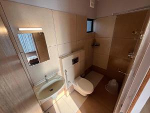 La petite salle de bains est pourvue de toilettes et d'un lavabo. dans l'établissement Rock View Resort, à Vagamon