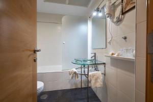 a bathroom with a toilet and a glass table at Hotel Real de Illescas in Illescas