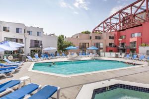 a pool at a hotel with blue chairs and a building at Old Town 1br near dining bars tech hubs PDX-15 in Portland