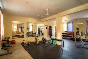 a room with a gym with bikes and mirrors at Roma Stays Sunset Holiday Apartments 3Bedrooms & swimming pool in Mombasa