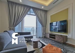 un soggiorno con grande TV e divano di Royce Residence Kuala Lumpur by Collective Haus a Kuala Lumpur