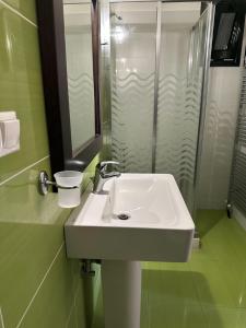 a bathroom with a white sink and a shower at DRYADES in Agios Nikolaos