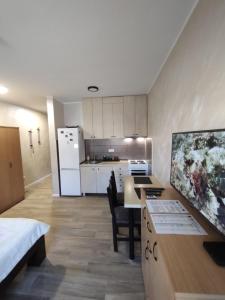 a room with a kitchen and a desk with a table at Left Coast studio apartment in Belgrade