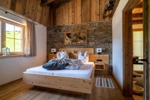 a bedroom with a bed and a brick wall at Wochenbrunner Chalets in Ellmau