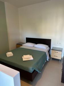 a bedroom with a bed with two towels on it at DRYADES in Agios Nikolaos