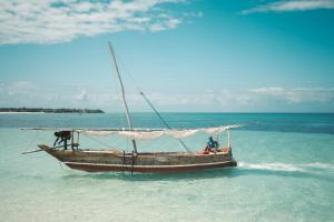 una barca in acqua su una spiaggia di Roma Stays Mwtapa Luxury Apartments 3 bedrooms & swimming pool a Mombasa