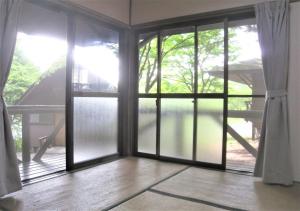 porta scorrevole in vetro in una stanza di Gozenyama Youth Travel Village - Vacation STAY 46760v 