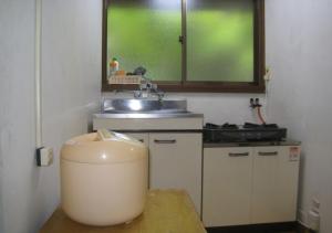 una piccola cucina con lavandino e finestra di Gozenyama Youth Travel Village - Vacation STAY 46760v 