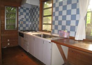 una cucina con lavandino e piastrelle bianche e blu di Gozenyama Youth Travel Village - Vacation STAY 46761v 