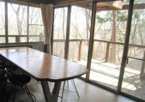 un tavolo in legno in una stanza con una grande finestra di Gozenyama Youth Travel Village - Vacation STAY 46761v 