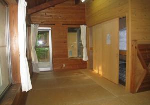 una camera con pareti e finestre in legno in una casa di Gozenyama Youth Travel Village - Vacation STAY 46761v 