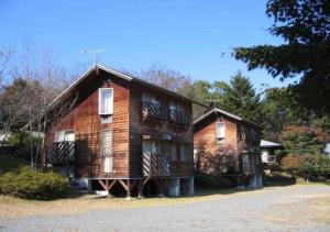 una grande casa in legno sul ciglio di una strada di Gozenyama Youth Travel Village - Vacation STAY 46761v 