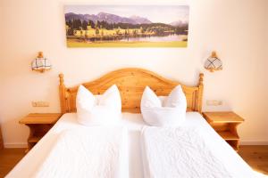 um quarto com uma cama com duas almofadas brancas em Fewo Schönes Ammertal em Oberammergau