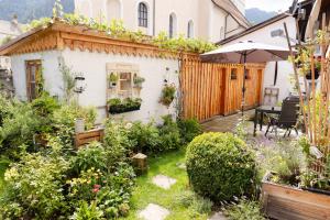 a garden in front of a house with an umbrella at Fewo Schönes Ammertal in Oberammergau