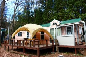 een klein huis met een terras en een tent bij Work Shop Camp Resort Forest and Lake Paradise - Vacation STAY 85268v in Fujikawaguchiko