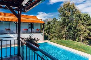 a house with a swimming pool on a balcony at Estalagem Bela Vista in Mondim de Basto