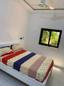 Cama en habitación blanca con ventana en Belle villa neuve meublée à Baguida en Baguida