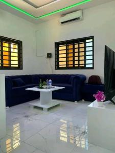 sala de estar con sofá azul y mesa en Belle villa neuve meublée à Baguida en Baguida