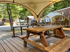 una mesa de picnic en una terraza de madera con una tienda de campaña en Work Shop Camp Resort Forest and Lake Paradise - Vacation STAY 85271v, en Fujikawaguchiko