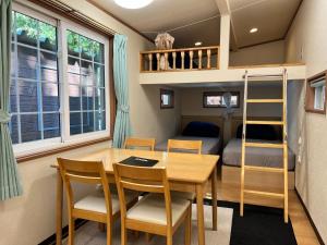 Cette chambre dispose d'une table, de chaises et de lits superposés. dans l'établissement Work Shop Camp Resort Forest and Lake Paradise - Vacation STAY 85271v, à Fujikawaguchiko