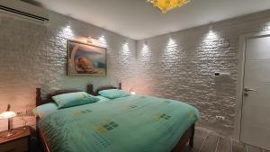 sypialnia z łóżkiem i ceglaną ścianą w obiekcie Waterfront Townhouse Sunset View with garage w mieście Bigova