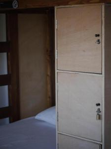 a bedroom with a dresser next to a bed at Hostel & Surfcamp 55 in Ericeira