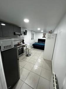 a kitchen and a living room with a couch at Petit paradis pour 2 personnes in Garges-lès-Gonesse
