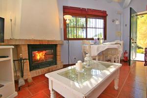 sala de estar con chimenea y mesa en Casas Rurales Los Algarrobales en El Gastor