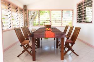a dining room with a wooden table and chairs at Bonnen Kare in Grand Anse