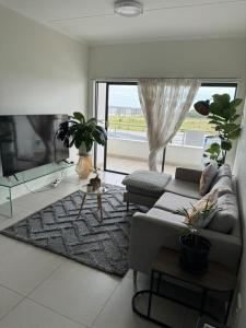 a living room with a couch and a large window at Beehive in Midrand