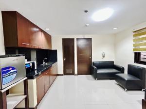 a large room with two chairs and a kitchen at OYO 1045 Rayjan Apartelle in Manila