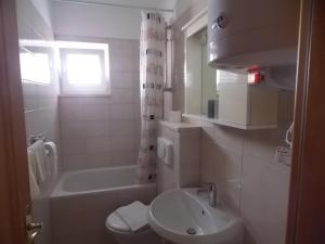 een badkamer met een wastafel, een bad en een toilet bij Matea in Novalja +11 foto's