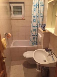 een badkamer met een wastafel, een toilet en een bad bij Matea in Novalja