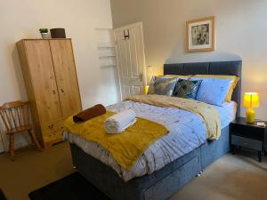 Un dormitorio con una cama azul con toallas. en Branxiar Suite - 1bedroom Executive Suite & Apartment in Wallsend en Old Walker